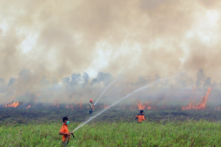 En esta foto de archivo del sábado 5 de septiembre de 2015, los bomberos rocían agua para contener un incendio forestal en Ogan Ilir, Sumatra del Sur, Indonesia (Foto de archivo/AP)
