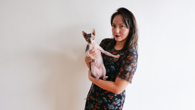 The director Amanda Nell Eu. She is holding a hairless cat.