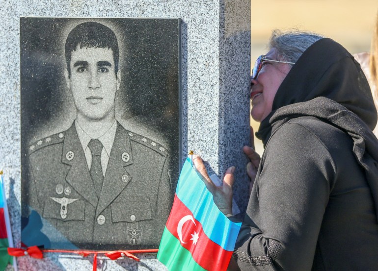 A woman grieves at a cemetery during a commemoration for Azeri soldiers killed in the war over the Nagorno-Karabakh