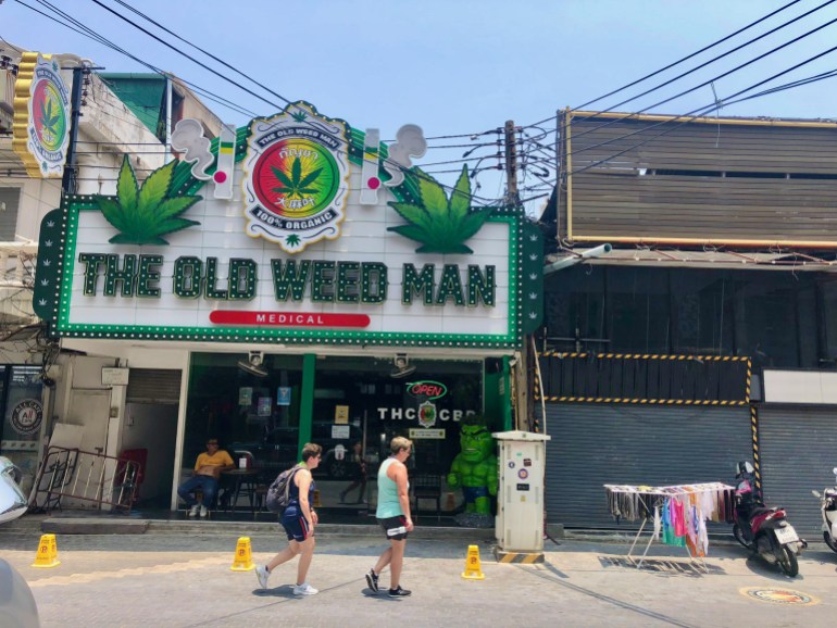 A cannabis shop's storefront dominates a street in Thailand.