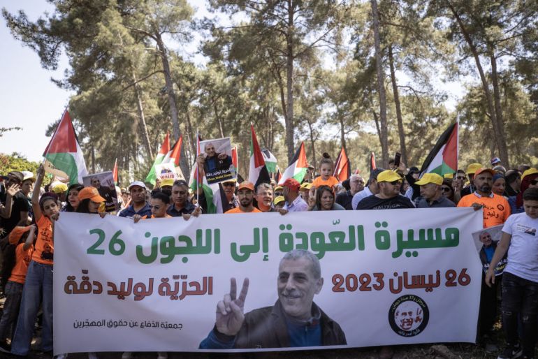 Des Palestiniens portent le drapeau et des photographies du prisonnier palestinien de la prison israélienne Walid Daqqa, atteint d'un cancer de la moelle épinière