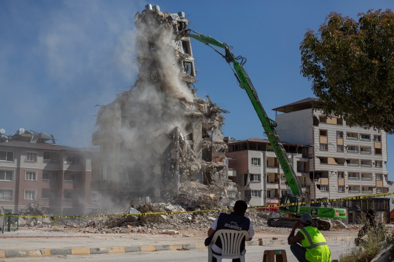 Sebuah bangunan yang rusak akibat gempa bumi dihancurkan di Antakya 