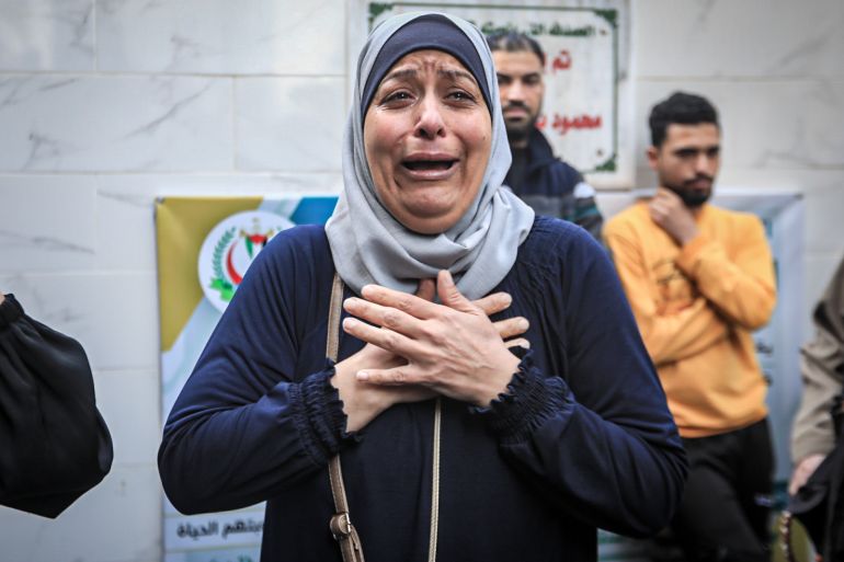 A woman mourns her friend who was killed along with her husband and son in an Israeli airstrike on their building in Gaza city
