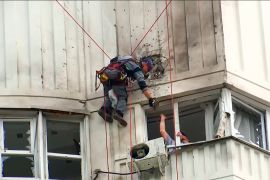 Investigators inspect a building after a drone attacked the apartment in Moscow on Tuesday