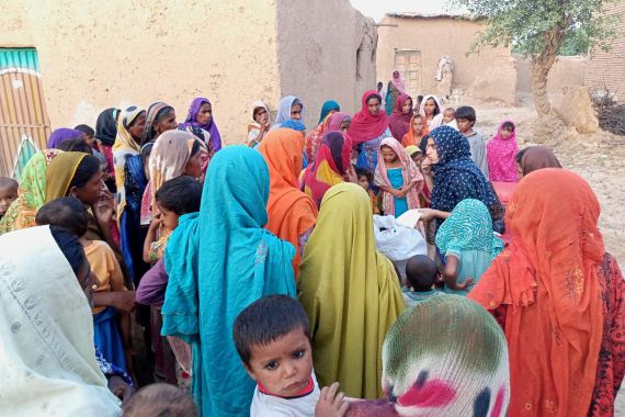 A woman speaks to a crowd of women in Balochistan