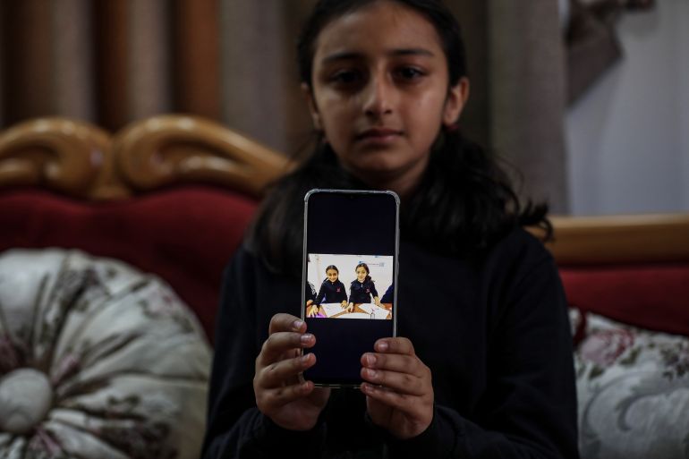 A girl holds a photo of her killed friend