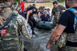 Police and state emergency service workers evacuate people from a flooded area of Kherson, Ukraine [Mykola Tymchenko via EPA-EFE]