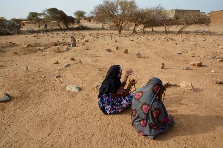 Women pray at a graveyard in Sudan