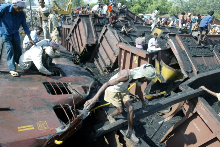 Rescue workers and labourers search the wreckage of a goods train and a passenger train that collided with each other on Wednesday