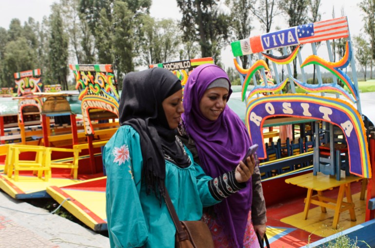 Muslim women walk past trajineras (boats) at the canals of Xochimilco as they celebrate Eid in Mexico City 