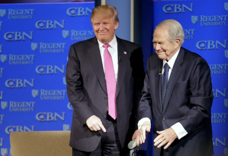 Republican presidential candidate Donald Trump (L) is greeted by Pat Robertson