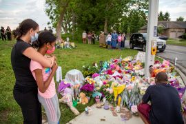 People hug at a makeshift memorial to a Muslim family that was fatally run down in London, Ontario, Canada in 2021