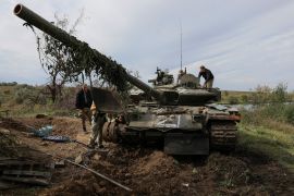 Ukrainian servicemen repair a Russian tank captured during a counteroffensive operation