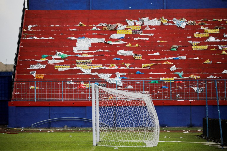 A view of the litter strewn stands at the Kanjuruhan Stadium after October's disaster. There is a football goal in front.