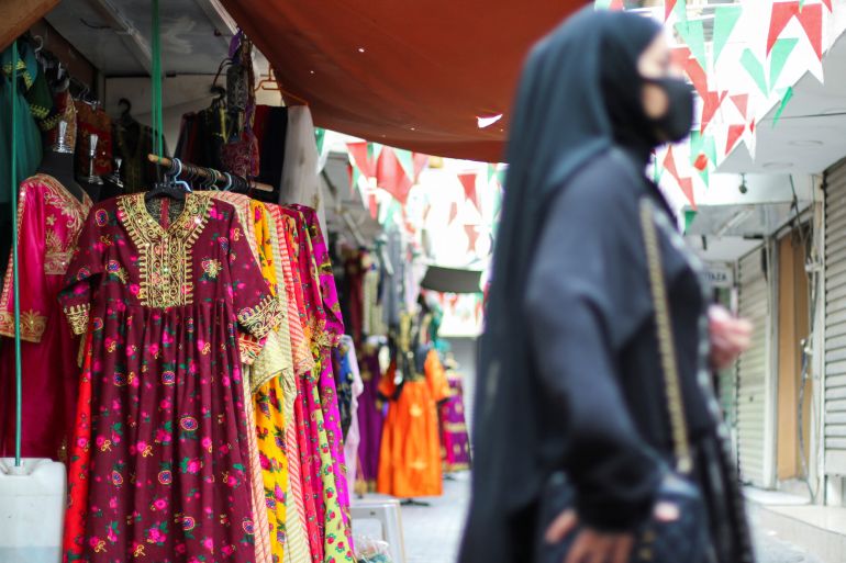 A Bahraini woman is seen shopping for an Arabic traditional women's outfit "Jalabia" ahead of Eid at a traditional shopping Souq in Manama, Bahrain