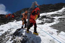 Ngima Tashi Sherpa walks with the Malaysian climber on his back after rescuing him from the death zone above camp four at Everest [Gelje Sherpa/Handout via Reuters]