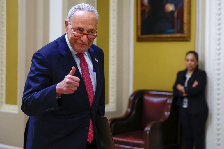 O líder da maioria no Senado dos EUA, Chuck Schumer (D-NY), dá um sinal de positivo depois que o acordo foi aprovado, ele parece feliz