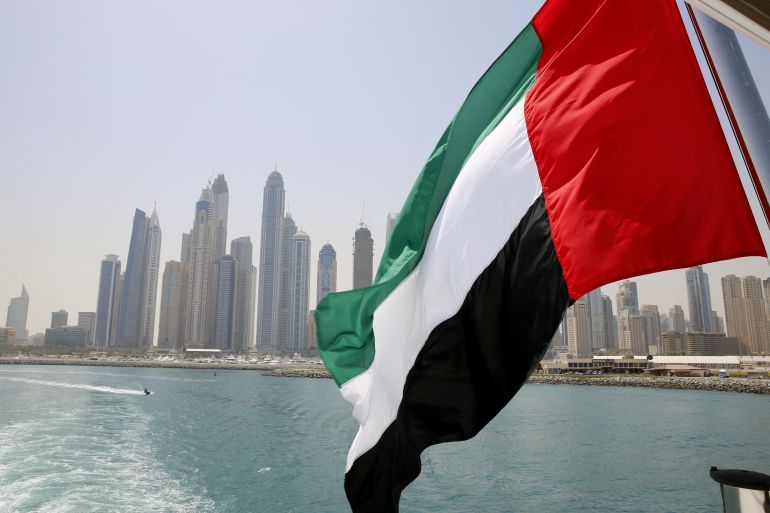 The UAE flag flies over a boat at Dubai Marina, Dubai, United Arab Emirates