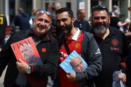 United fans hold match programmes featuring City manager Guardiola and United manager ten Hag before the match [Paul Childs/Action Images via Reuters]