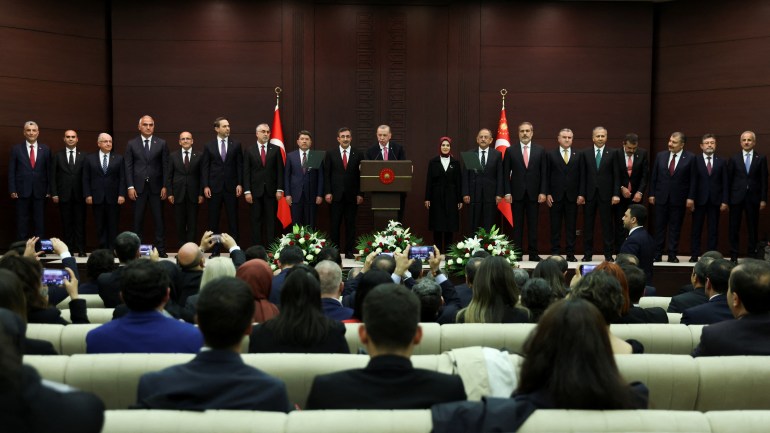 Turkish President Tayyip Erdogan speaks next to new cabinet members during a news conference in Ankara