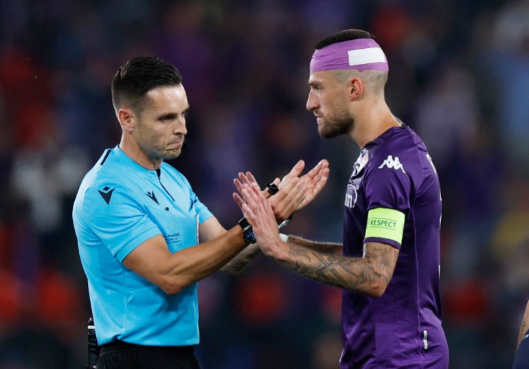 Football - European Conference League - Final - Fiorentina vs West Ham United - Eden Arena, Prague, Czech Republic - 7 June 2023 Fiorentina's side after being thrown the cup by West Ham United fans Cristiano Biraghi talks with referee Carlos del Cerro Reuters/David W. Cerny