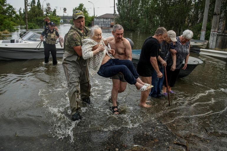 Rescuers evacuate local residents from a flooded area after the Nova Kakhovka dam breach, in Kherson, Ukraine, June 7, 2023