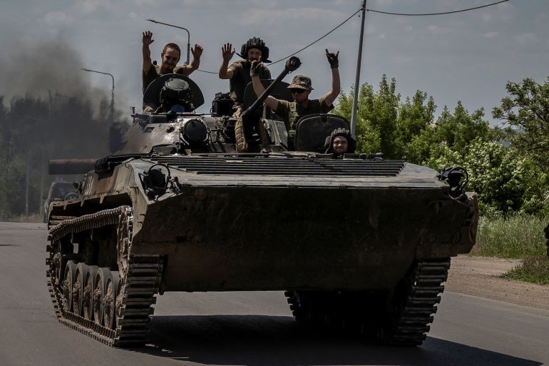 Ukrainian service members ride a BMP-1 infantry fighting vehicle