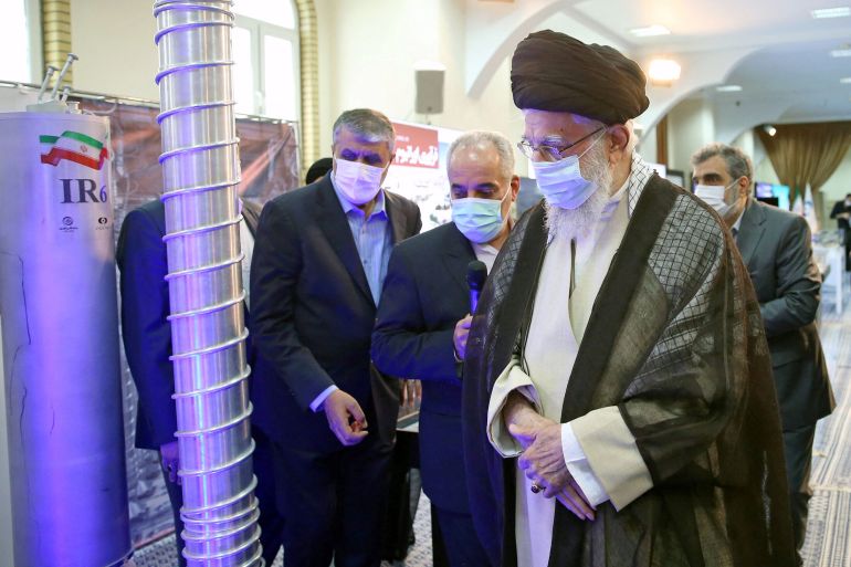 Supreme leader Khamenei, wearing a mask, looks at the centrifuges