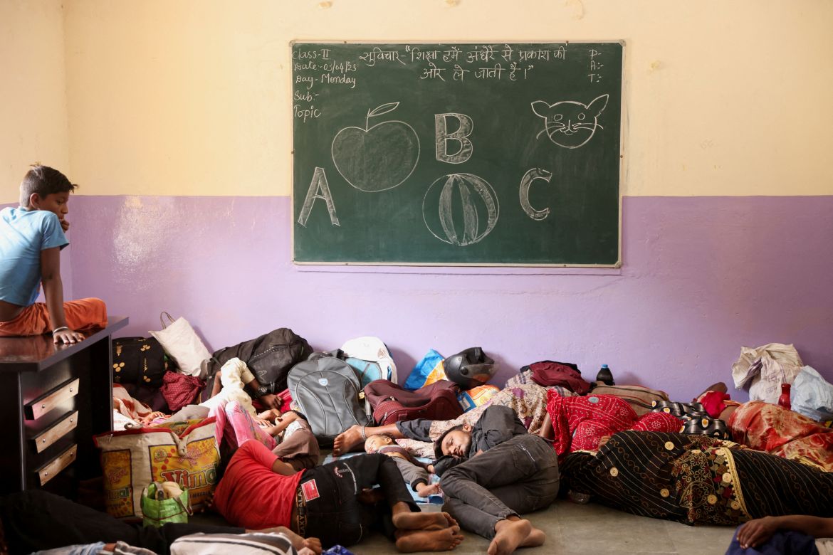 People evacuated from Kandla port sleep inside a classroom in a school converted into a shelter,