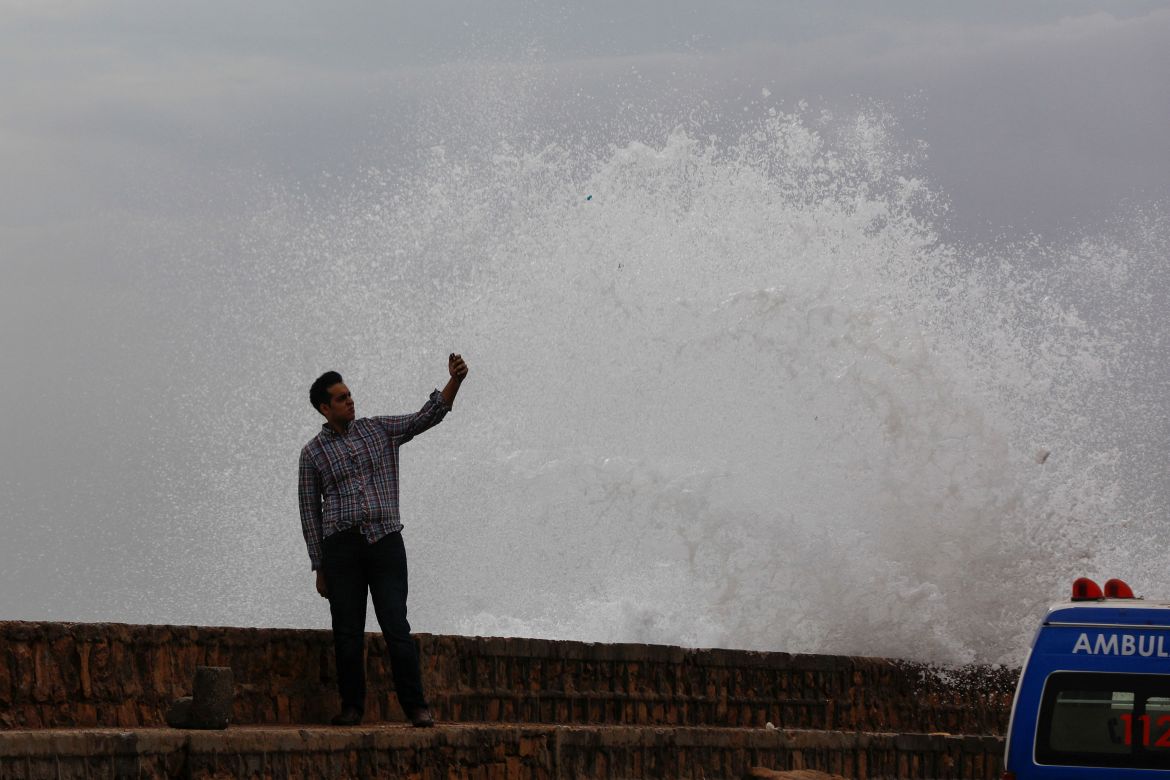 A man takes a selfie beside a rising wave, before the arrival of the cyclonic storm, Biparjoy, over the Arabian Sea,