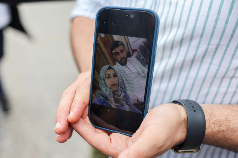 Syrian Kassam Abozeed, 34, who says his wife Israa and brother-in-law were onboard a boat with migrants that capsized at open sea off Greece, demonstrates a photo of him and his wife, at the port of Kalamata, Greece, June 15, 2023. REUTERS/Stelios Misinas