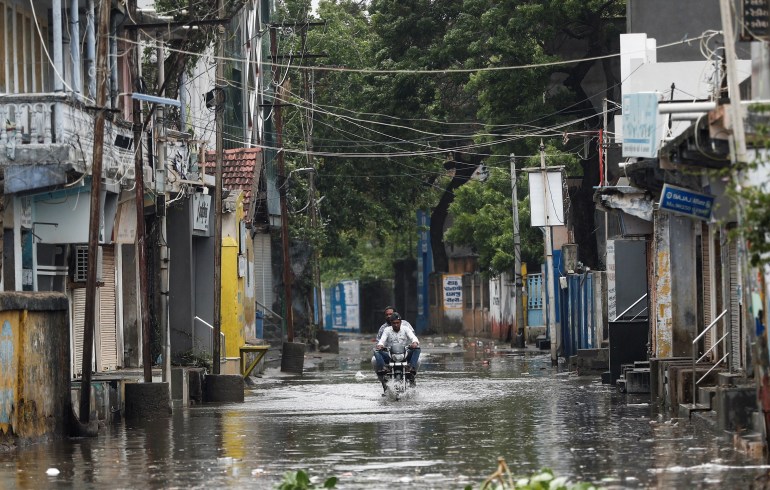 man rides a motorcycle through a waterlogged street in Mandvi before the arrival of cyclone Biparjoy in the western state of Gujarat, India, June 15, 2023. REUTERS/Francis Mascarenhas 