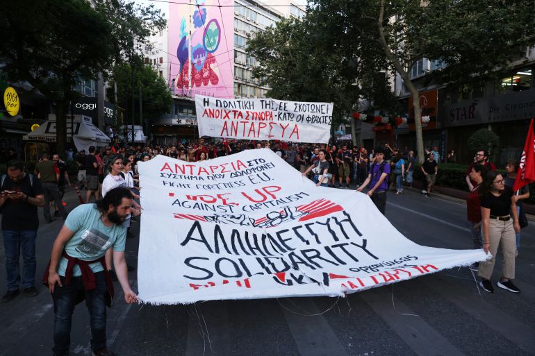 Protesters hold banners during a demonstration, following a deadly migrant shipwreck off Greece