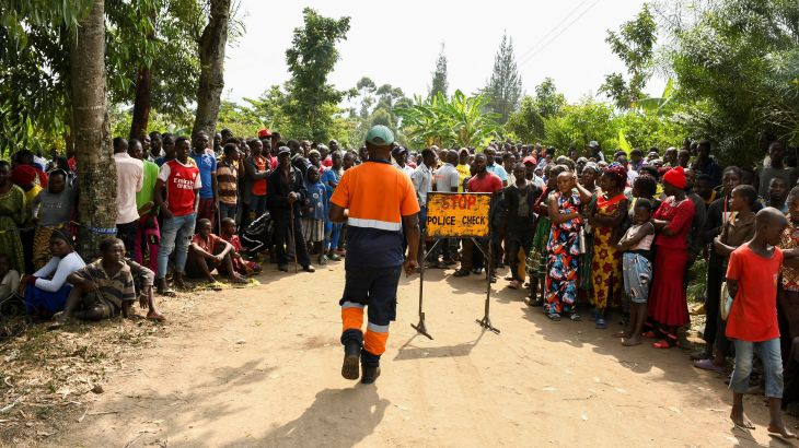 Locals gather at the cordoned scene outside the Mpondwe Lhubirira Secondary School in Mpondwe, Uganda