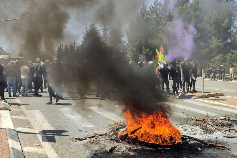 A bonfire burns in a street as members of Israel's Druze minority protest plans to build a series of wind turbines in Kfar Vradim in the Israeli-occupied Golan Heights