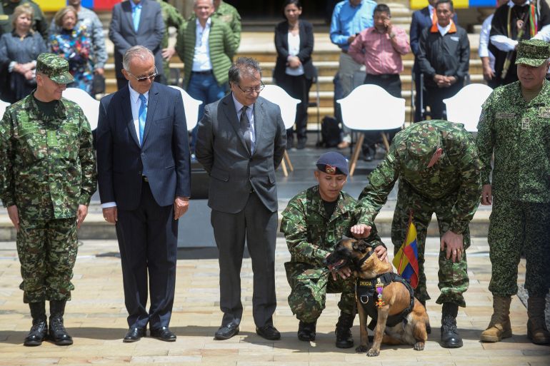 Colombia's Defense Minister Ivan Velasquez and President Gustavo Petro look at a dog who helped in the rescue of the surviving children from a Cessna 206 plane that crashed in the thick jungle, in Bogota, Colombia June 26, 2023. REUTERS/Vannessa Jimenez