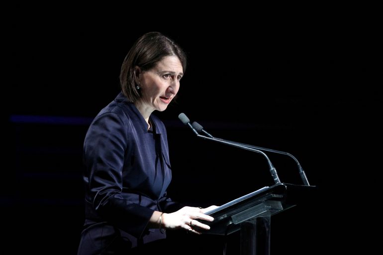 Gladys Berejiklian speaking when she was NSW premier. She is standing at a lectern with a microphone.