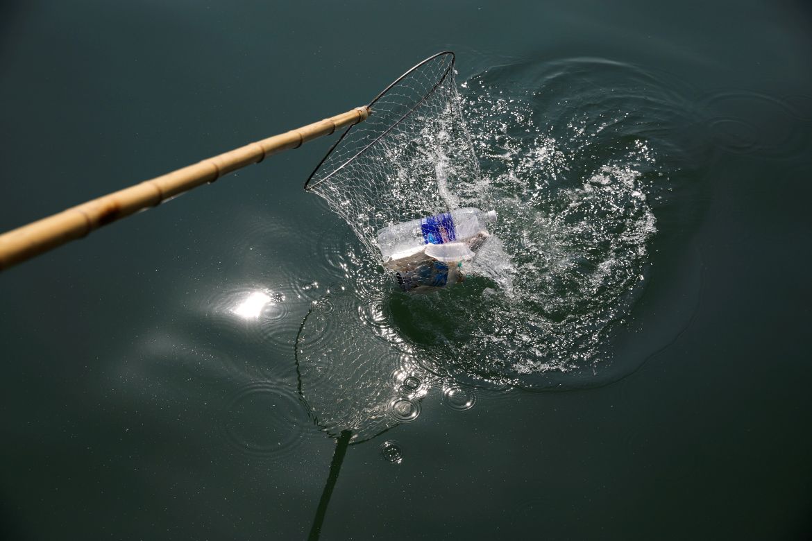 a worker picks up trash from Ha Long Bay in northeast Vietnam.