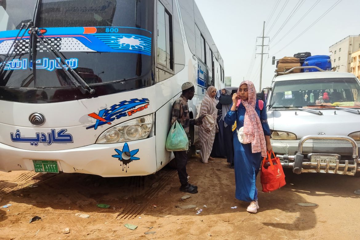 Sudanese people wait to board a bus in Khartoum