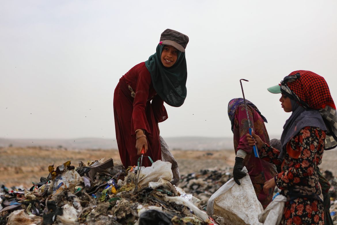 In this picture taken on June 3, 2023, children sift through rubbish with scythes, as they look for plastic items to sell for recycling, at a dump site near the village of Hazreh in Syria's northwestern Idlib province.