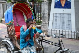 A rickshaw puller quenches his thirst with a juice during the heatwave in Dhaka [Munir uz Zaman/AFP]