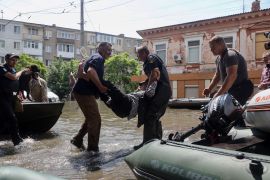 Ukrainian security forces carry an elderly resident to a boat during an evacuation from a flooded area in Kherson on June 7, 2023, following damages sustained at Kakhovka hydroelectric power plant dam [Oleksandr Gimanov/AFP]