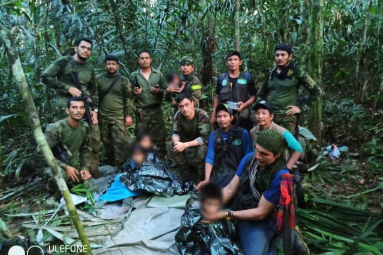 In this handout photo released on June 9, 2023, by the Colombian Presidency, members the Army pose with four Indigenous children who were found alive after spending more than a month lost in the Colombian Amazon jungle following the crash of a small plane