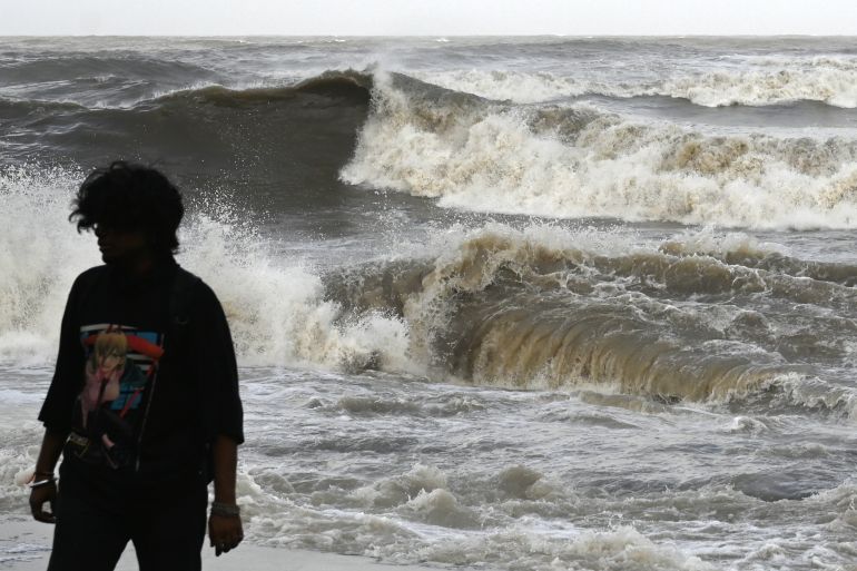 A man walks away from the seafront as high tidal waves hit the coast in Mumbai