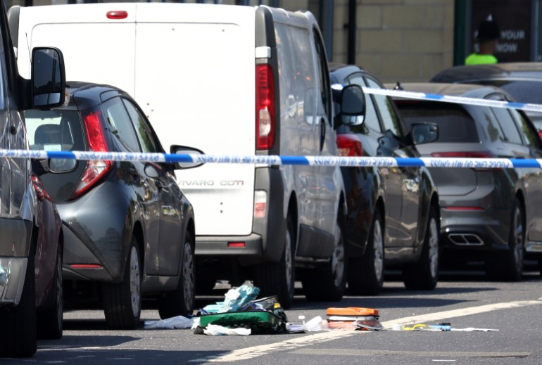 Un oficial de policía se encuentra junto a un cordón, cerca del equipo médico esparcido por Ilkeston Road en Nottingham, en el centro de Inglaterra, durante un 