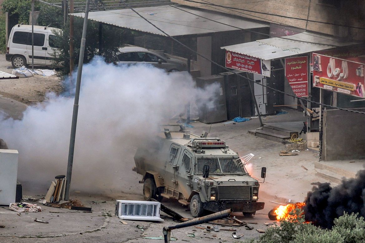 An explosive charge left by Palestinians detonates by an Israeli armoured vehicle during an Israeli army raid in Jenin
