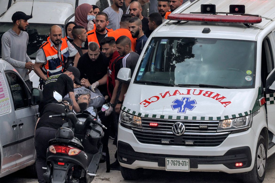 An injured man is transported from an ambulance by paramedics in Jenin in the occupied West Bank