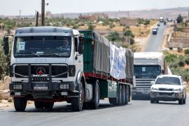 Trucks move in a United Nations aid convoy