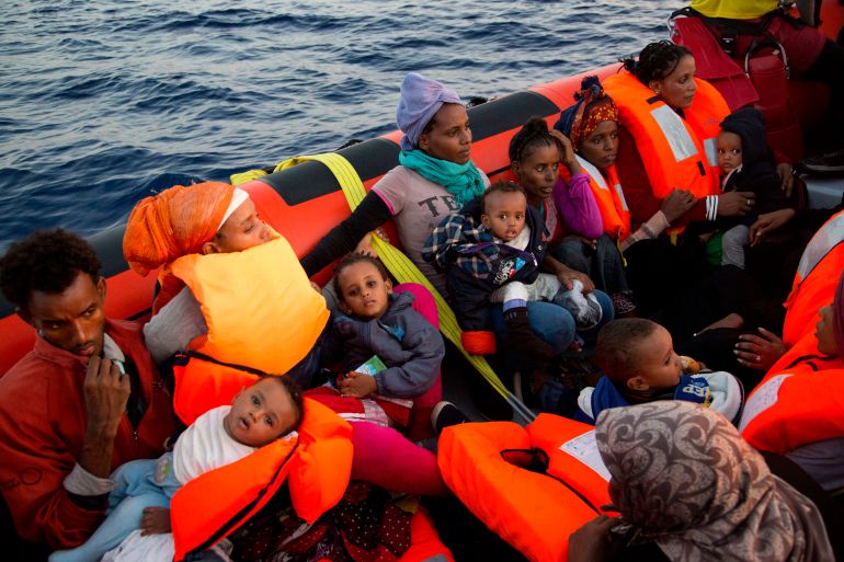 Migrants from Eritrea hold their children after been rescued from a crowded wooden boat