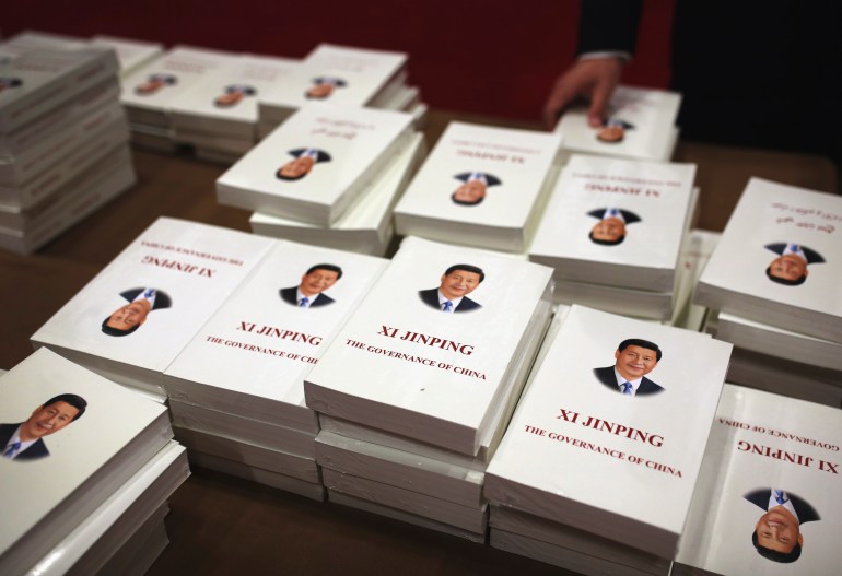 Books by Xi jinping on display. The covers are white and there is a formal portrait of Xi on the cover above the book's title 